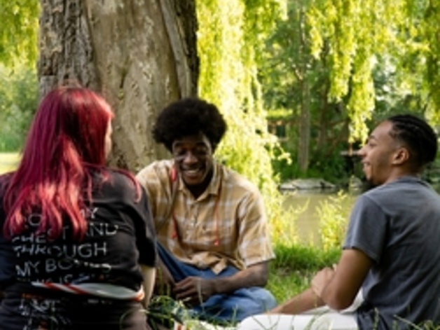 group of people sitting under a tree